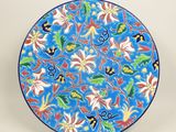 un gros plan d'une assiette bleue ornée de fleurs et de feuilles