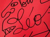 a red poster with a drawing of a man ' s face on it