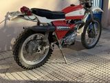 a red and white dirt bike parked in front of a building