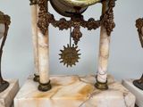 a clock that is sitting on top of a marble stand