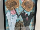 boîte-vitrine contenant des gants, des gants et un chapeau posés sur une table