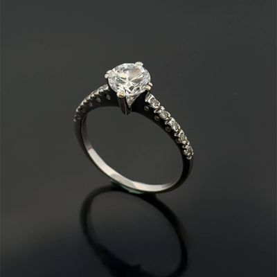 a close up of a diamond engagement ring on a black surface