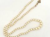 gros plan d'un collier de perles sur une surface blanche