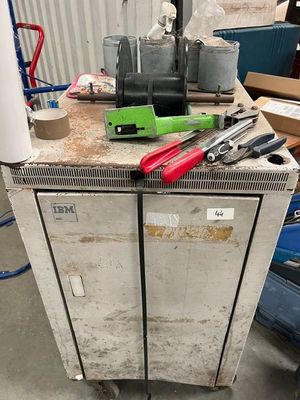 une armoire métallique sur laquelle sont posés des outils, dans un garage