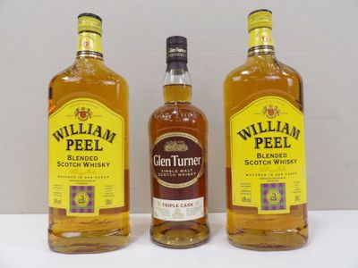 three bottles of whiskey sitting on top of a white table