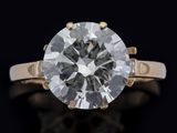a close up of a diamond ring on a black surface