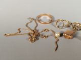 a lot of gold rings and necklaces on a table