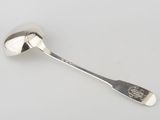 silver spoon on a white surface with a monogram on the handle