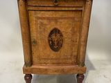 une vieille armoire en bois avec un plateau en marbre, posée sur un socle