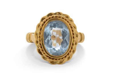 Gros plan sur une bague en or ornée d'une topaze bleue