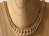 a close up of a gold chain necklace on a mannequin