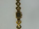 an image of a gold wrist watch with a chain attached to it