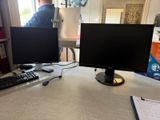 two monitors and a keyboard sitting on a desk