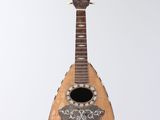 a guitar hanging from a string on a white wall