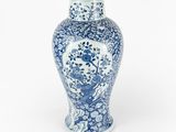 un vase bleu et blanc posé sur une surface blanche