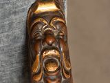 a close up of a wooden chair with a face on it