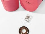 louis vus pink and black box with a coin and a tag on it