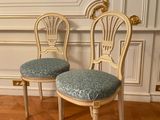 pair of chairs with blue upholstered cushions in a white room