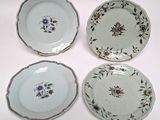 three plates with floral designs on them sitting on a white surface