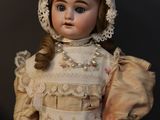 a doll that is wearing a bonnet and dress