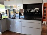 a kitchen that has a television on the wall in it