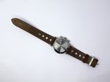 an image of a watch with a brown leather strap on a white surface