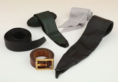 a belt, tie, and other accessories laid out on a table