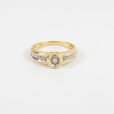 a yellow gold ring with a white diamond and two small diamonds