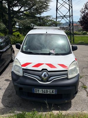 une camionnette blanche garée sur un parking à côté d'une voiture noire