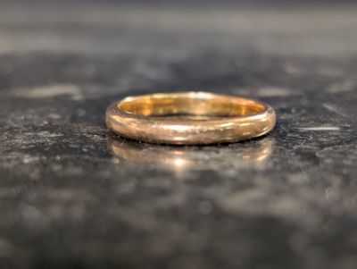 un gros plan d'une alliance en or posée sur une table