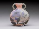 a vase with flowers painted on it sitting on a table