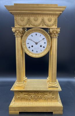 l'image d'une horloge en or posée sur une table