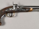 an old gun that is on display on a white surface