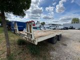 a flatbed truck that is parked in a parking lot