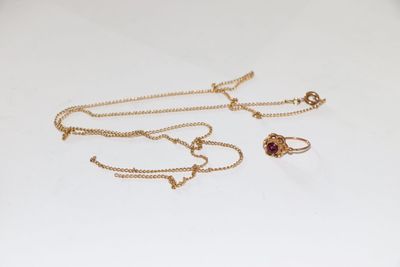 un gros plan d'un collier et d'une paire de boucles d'oreilles posés sur une surface blanche