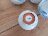 four cups on a wooden table with blue and white designs on them