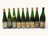 six bouteilles de vin sont alignées sur une surface blanche