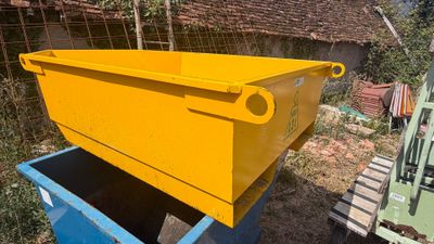 un conteneur jaune posé sur un conteneur bleu