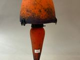 an orange and blue lamp with a black cord on a white background
