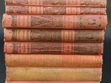 six old books stacked on top of each other on a table