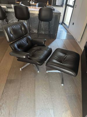 un fauteuil et un repose-pieds en cuir noir dans un salon