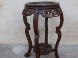 une petite table en bois sur laquelle se trouve une plante