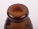 a brown vase with a brown lid on a white table