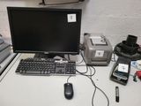 un écran d'ordinateur, un clavier, une souris et d'autres appareils électroniques posés sur un bureau