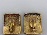 a pair of gold plated earrings on a white surface