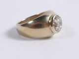 a close up of a gold ring with a diamond on it