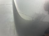 someone is peeling the paint off of a car ' s front bumper
