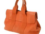 an orange leather handbag on a white background