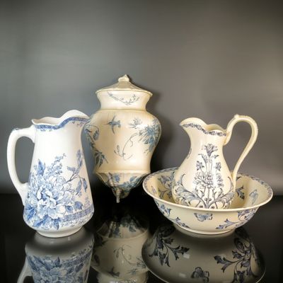 three blue and white vases and a bowl on a table