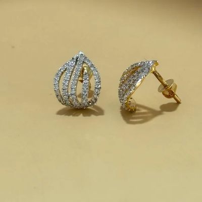 two tone gold and diamond earrings on a beige background